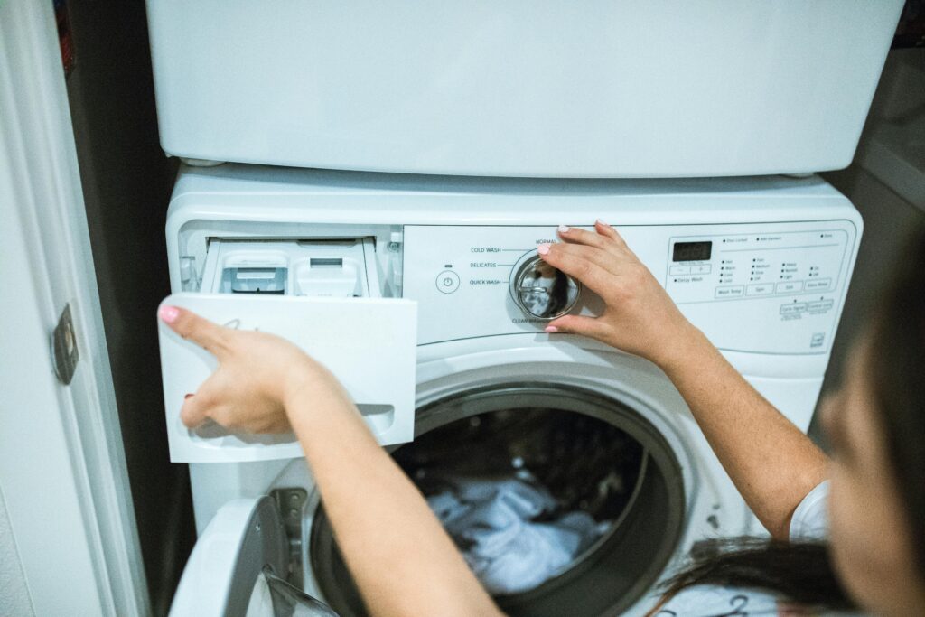 a woman doing laundry with a front load washer and it is a stackable